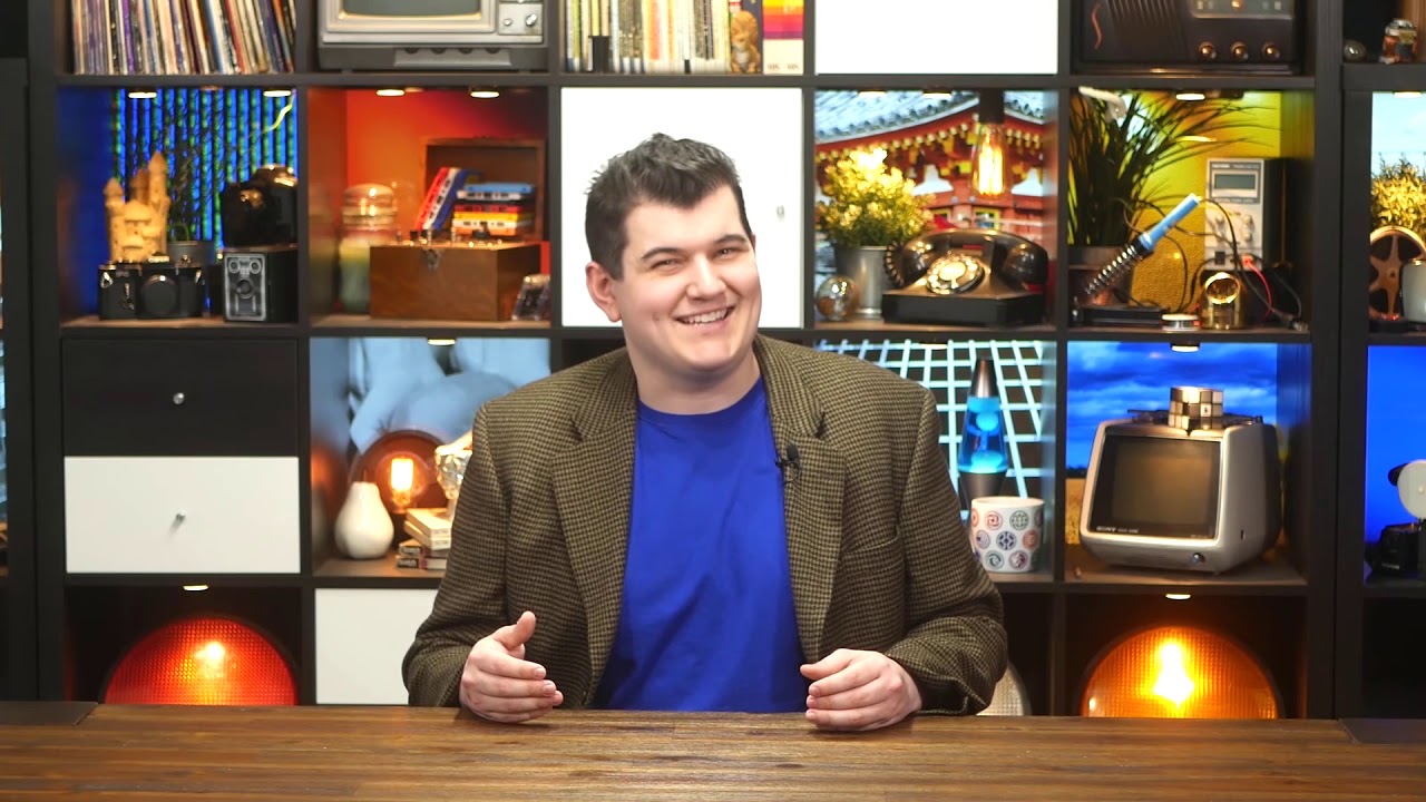Alex Watson sitting on set smiling at camera